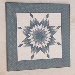 Vintage hand crafted blue star quilt wall hanging mounted over wooden canvas